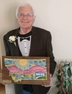 Jerry Rukavina posing with his MFPE Hall of Fame plaque